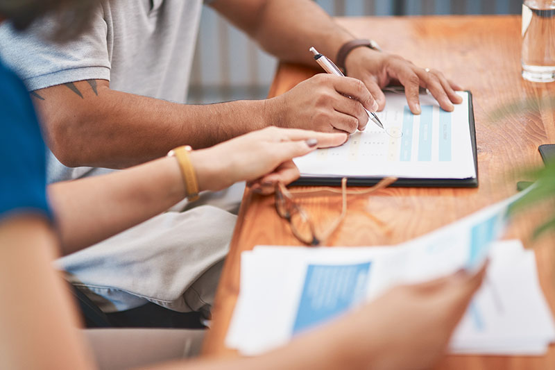 Couple, hands and sign of document, table and legal in office, life cover or insurance with pen. Paperwork, people and agreement of contract, glasses and together for marriage, love and retirement
